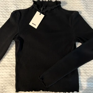 Svart tröja men kort krage  - Oanvänd svart långärmad top med låg krage. Från bikbok, oanvänd, med lappen kvar.