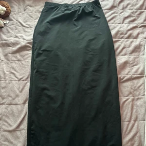 Lång tajt kjol - Säljer denna kjol för den ej kommer till användning alls. Den är fin och slutar vid fötterna 