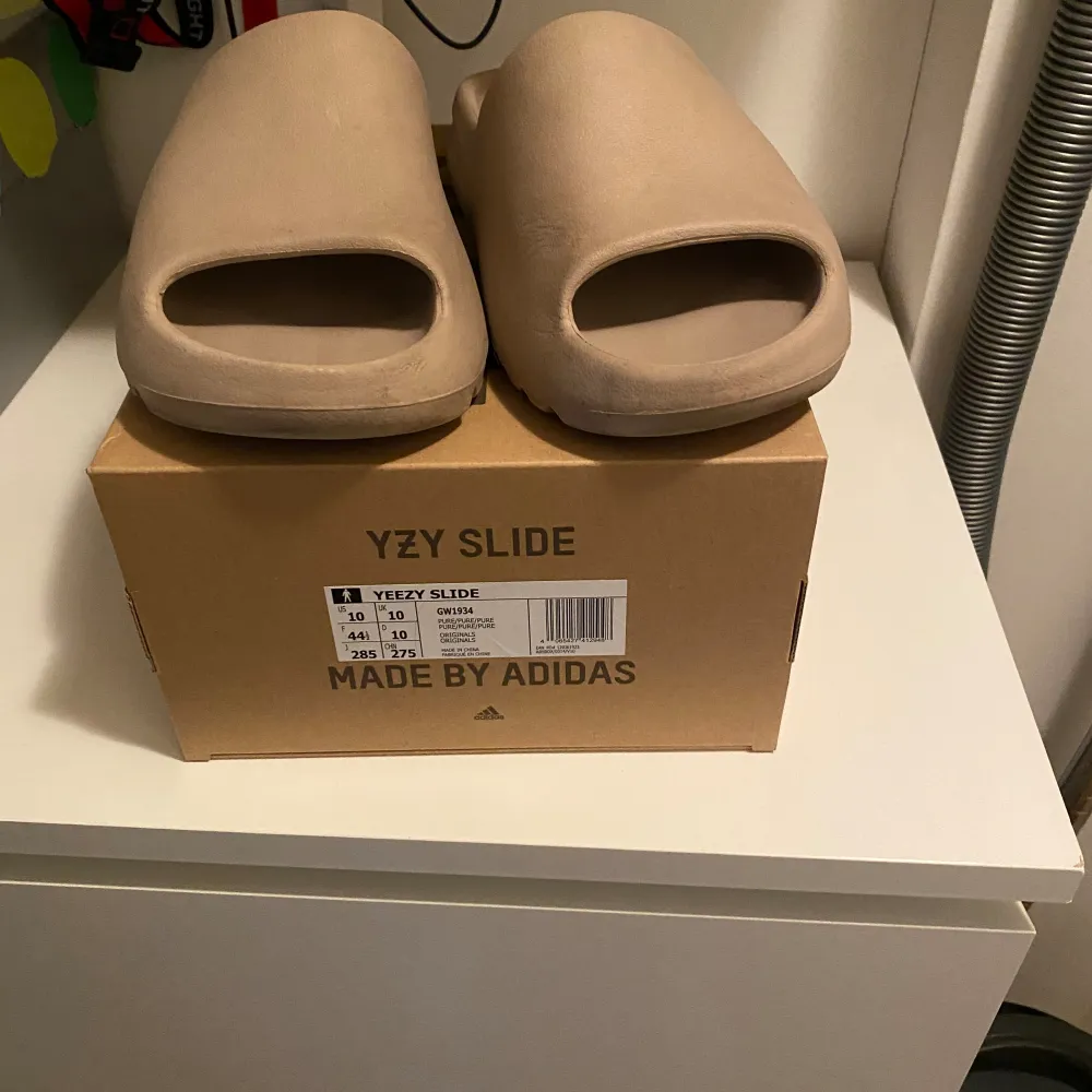 Yeezy slides Köpta 2022-05-16, användes under sommaren 2022 men efter det har jag ej använt dem. Tillkommer med original sko låda. Storlek 44 1/2 men sitter som 43. . Skor.
