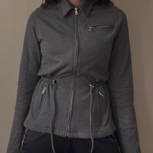 Vintage Prada Cotton Knit Jacket - Beautiful Vintage Prada Milano Cotton Knit Zip Sweater Jacket in Grey.  Silver colored metal hardware with embossed “Prada Milano”.  1 Top Zip and 2 Side Zip Pockets + a  drawstring feature for an adjustable waist. Some yellowing around shoulders 