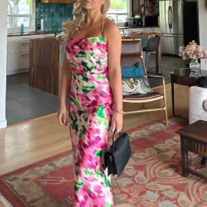 Mönstrad klänning från Ellos - Mönstrad maxiklännning i satintyg i vackra färger. Storlek 34. Fint urringad i ryggen med tunna korsade band som går att dra åt med dragsko. Använd en gång, i nyskick. Nypris  1299kr. 