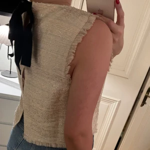 Blus med rosett  - Guldig/beige blus med rosett bak. Från Zara i storlek M, passar en S
