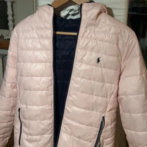 Ralph Lauren jacka  - Oanvänd tvåsidig Ralp Lauren jacka Storlek : Barnstorlek XL (16 år) Färg : Mörkblå och ljusrosa  Nypris : 2200 kr  Säljer för 800 kr  