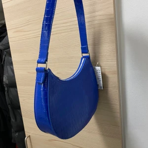 Blå handväska H&M - Väska i nyskick från H&M, aldrig använd.