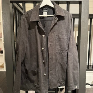 HOPE Jacka - Säljer en svart jacka/overshirt från HOPE i storlek 50 (Herr)/42 (Dam). Oversized fit. Skulle uppskatta storleken som en Large.
