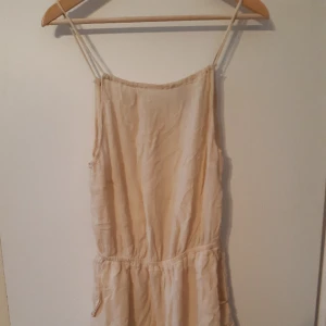 Jumpsuit  - Vacker och skön jumpsuit i svagt rynkat naturvit/beige tyg. Knappt använd, ser skrynklig ut på bilderna då jag ej har ett strykjärn för tillfället.
