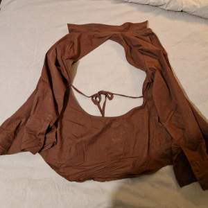 Mörkbrun tunn skjorta med band i ryggen för att kunna dra åt tröjan! Säljes pga sitter för tajt i ärmarna på mig, använd 1 gång :)