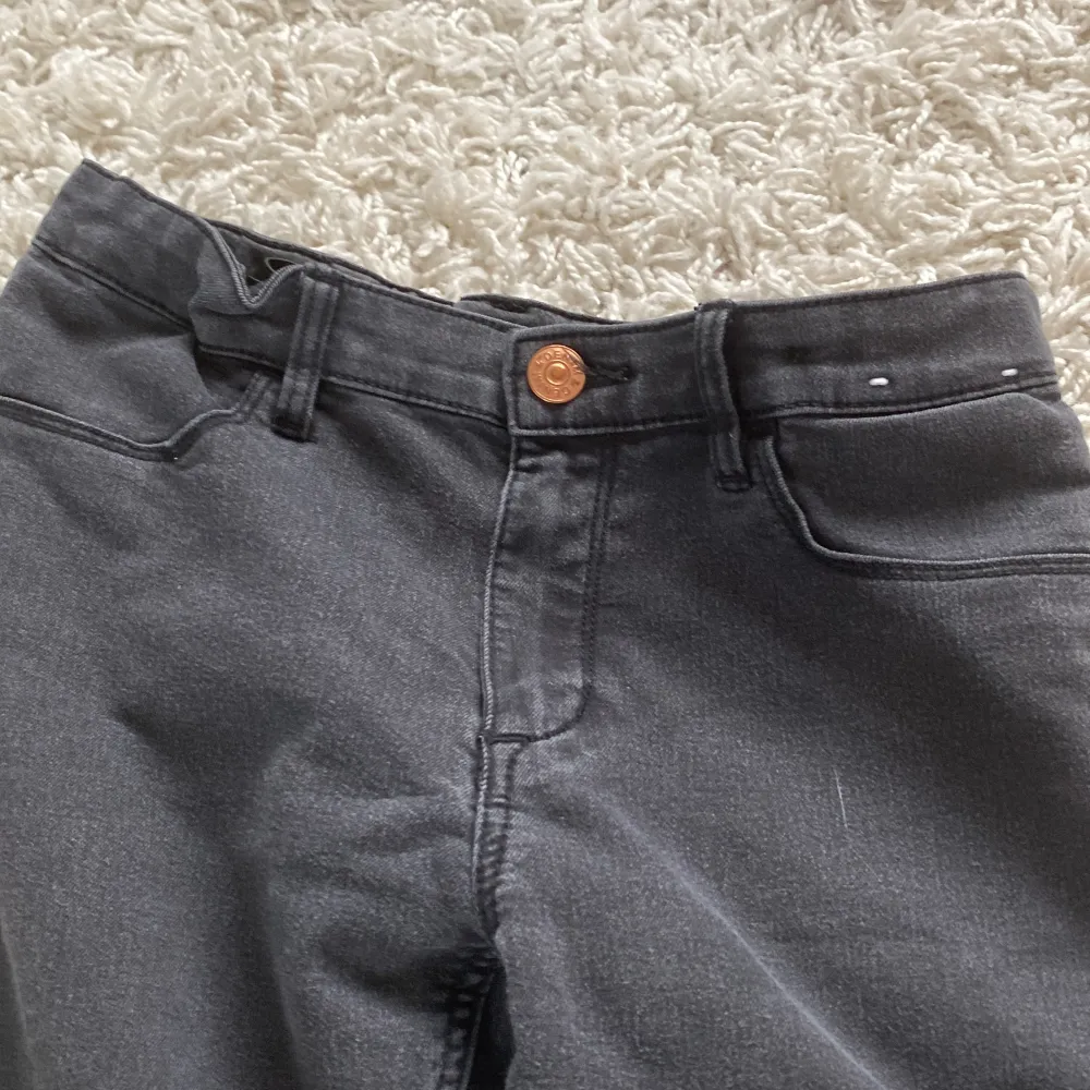 Ett par svarta skinny fit jeans i storlek 152. Byxorna har en knapp och dragkedja framtill samt fickor både fram och bak. Tillverkade i Bangladesh.. Jeans & Byxor.