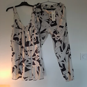 Svartvita byxor från Roxy - Ett par svartvita byxor från Roxy med ett abstrakt mönster. Byxorna har en elastisk midja och är tillverkade i ett lätt och bekvämt material.