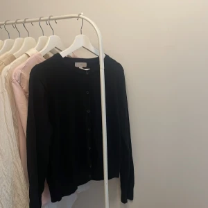 hm kofta svart  - Denna koftan är använd ett par gånger och är i bra skick. Super mjuk och skön. Den är i storlek M men har krympt lite så det går att använda den om du har storlek S. Alla knappar är på. 