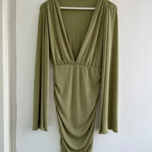 Klänning - Jätte fin klänning med perfekt passform bakitill. Skinande grön färg. Som ny!