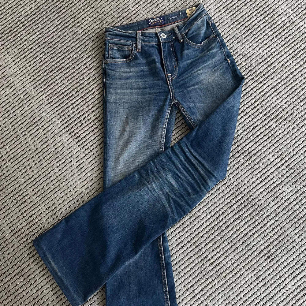 Ett par jättesnygga utsvängda, lågmidjade jeans från Crocker, i en modell som inte längre finns. Byxorna är i nyskick förutom en liten slitning i en söm (se bild 5) Utöver det är byxorna superfina och sitter som en smäck🥰 Storlek: W25 L32. Jeans & Byxor.