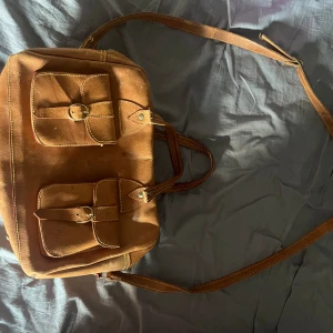 Brun axelremsväska  - Säljer en brun axelremsväska som är köpt secondhand. Frakt tillkommer!
