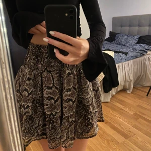 Volangkjol - Säljer denna coola volangkjol med ormskinnsmönster. Den är från Kappahls barnavdelning och är i storlek 158/164 men passar en xxs-xs. Knappt använd. Säljer för 79kr.