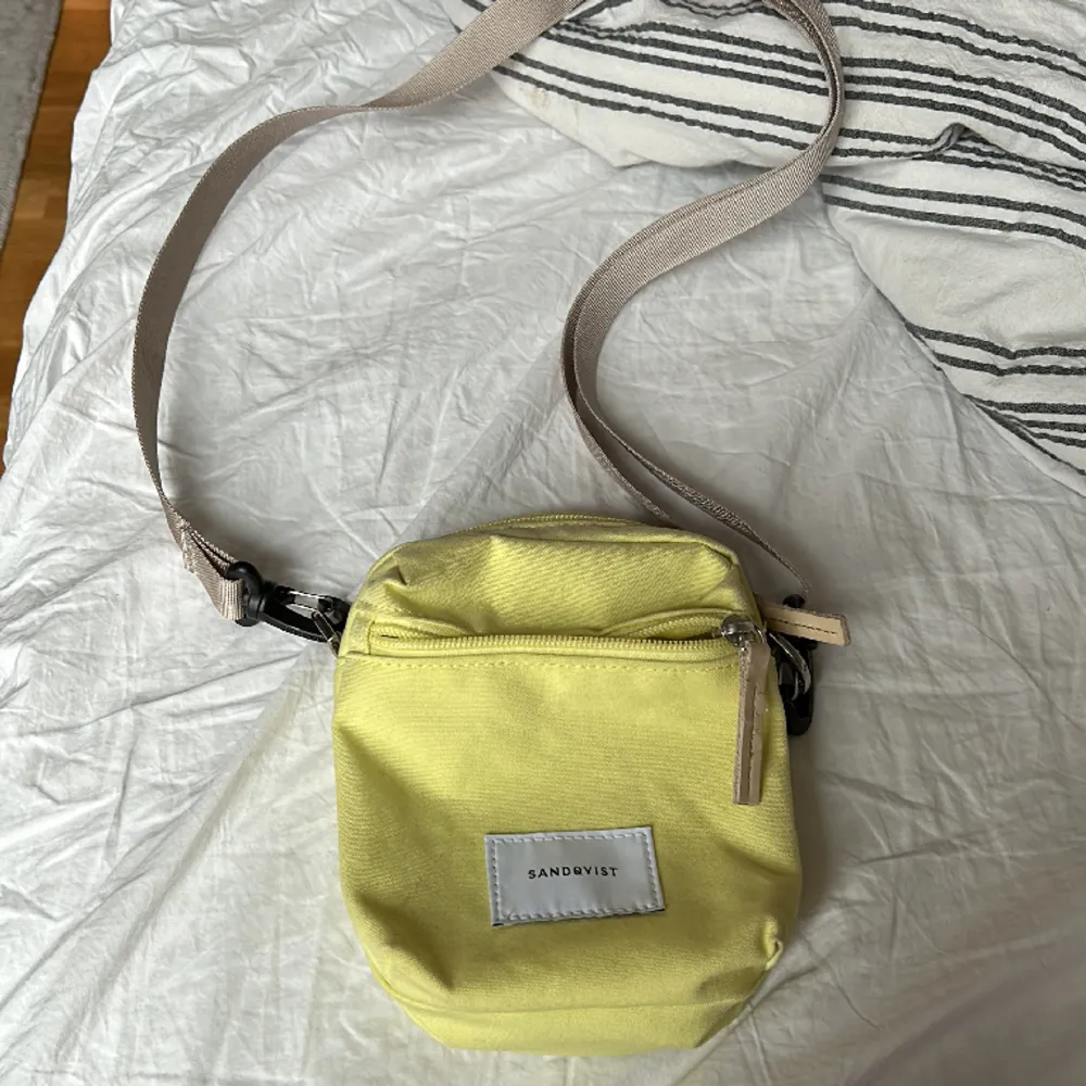 Liten Sandqvist väska i en gul färg. Väskor.