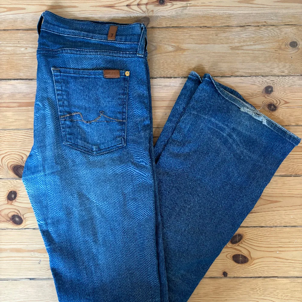 Blåa Bootcut jeans från 7 for all mankind.  Fin tvätt (något ljusare blå), med lite slitningar vid hälen.   Använda men gott skick (bortsett från slitningarna).   Storlek 32. . Jeans & Byxor.