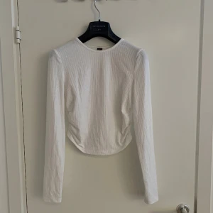 Vit långärmad tröja - Enkel långärmad som är längre fram och rynkade sidor. 