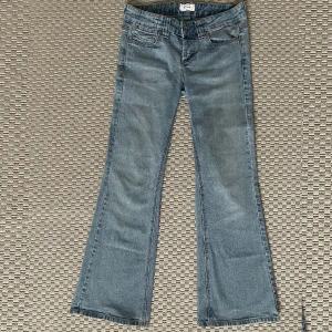 Lågmidjade Bootcut jeans - Ljusblåa väldigt lågmidjade bootcut jeans från top shop med snygga fickor, skriv till mig om ni vill veta de exakta måtten W27 L30💕 använd gärna köp nu🫶🏻