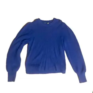 Blå stickad tröja som är relativt använd men är i gott skick.