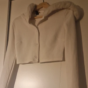 Vit kofta - Jag har en ny kofta som bara använts en gång med en krage som har päls runt den, priset är mycket billigt.