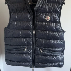 Moncler Gui Väst - Otroligt fin Moncler Gui i, -Storlek: 2 (S/M) -Skick 8/10 (Finns två minimala flaws, se 2 bilderna nedan) -Nypris: 8999kr -Vårat pris: 2999kr -Frakt: Ingår📦  Tveka inte att höra av dig vid minsta frågan!