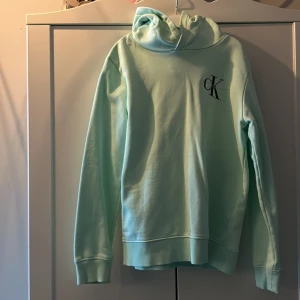 Calvin Klein Hoodie  - Mintgrön hoodie i väldigt fint skick. Sparsamt använd, passar barn ca 12 år storlek 152