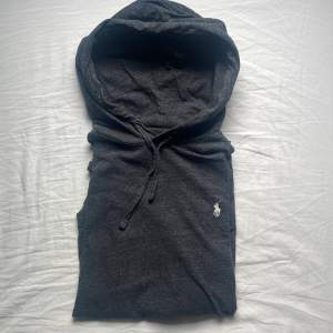 En grå Ralph lauren hoodie i tunt material som är riktigt skönt, perfekt för sommaren. Färgen speglas ganska bra på bilden med en vit logga. Storlek S. Priset är inte hugget i sten! Hör gärna av dig!