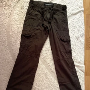 Coolaste cargobyxorna - Coolaste lågmidjade cargobyxorna köpta second hand. Har en snygg och söt knytdetalj i midjan och är i så fint skick. Storlek 164 men skulle säga att de passar en xs. Är aningen korta på mig som är 167💗