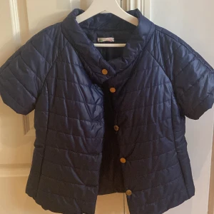 Kortärmad pufferjacka - Jag säljer den här super snygga marinblåa pufferjackan som är tillverkad i italien💕.Den är tyvärr lite förstor för mig därför säljer jag den💕. Jackan är i storlek M. 