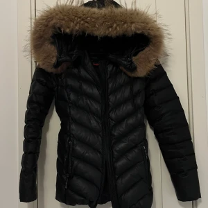 Vinterjacka  - Jag säljer min Chelsea vinterjacka med äkta päls. Jackan är använd ett fåtal gånger, på baksidan av jackan så är det ihopsytt då det blivit ett hål (inget som man lägger märke till) men annars är jackan i bra skick. Den är i storlek 34. 