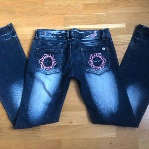 Crazy age jeans  - As snygga crazy age jeans med rosa detaljer och blekningar. Midjemåttet är 38cm och innerbenslängden är 79cm, skriv om du har några frågor💕