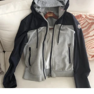 Moncler Vindjacka - Moncler Vindjacka 7/10 skick. Köpt för 2800. kan sänka priset o ordna en bra deal så båda är nöjda vid snabb och smidig affär. Hör av er om ni har frågor eller behöver veta något mer.  Det saknas även en knapp men det skall nog gå o ordna i nån affär
