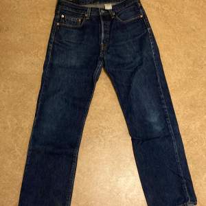 Mörkblåa Levis 501 jeans i regular fit.