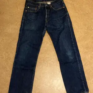 Mörkblåa Levis 501 jeans i regular fit.
