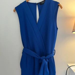 Byxdress - Byxdress i blått i storlek S. Använd fåtalgånger så i mycket bra skick! Fickor på sidorna.