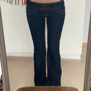 Lågmidjade jeans - Mörkblåa jeans med väldigt låg midja. Uppsprättade i fållen för att passa mig som är 166 cm.   Midjemått: 37 Innerbenslängd: 74
