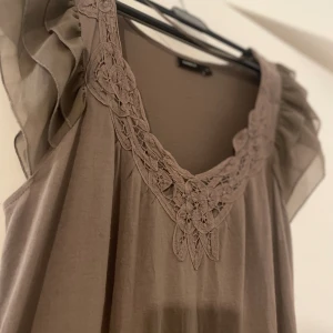 Brun volangklänning - Superfin brun klänning med vollangärmar, luftigt material.  Är 1.70 klänningen når lite ovanför mina knän. 