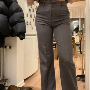 Grå kostymbyxor - Grå högmidjadede kostymbyxor med söm framtill. Jättebrkväma och så användbara! Sitter så bra! Hål i den ena fickan men inget som stör.  Skriv vid fler bilder eller intresse!🩶