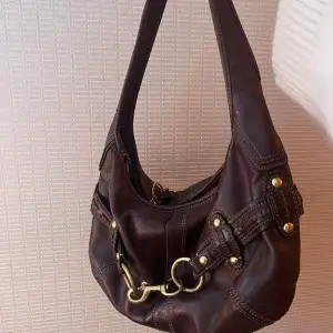 Säljer denna Coach Dark Brown Buckle Bag som är köpt från Luxury By Ho. Så snygg och bra kvalitet. 