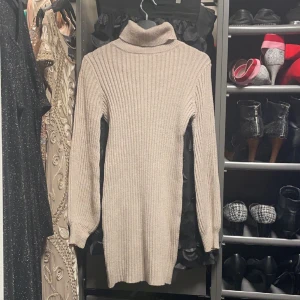 Stickad klänning  - En brun beige klänning med polo krage