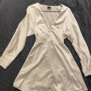 Klänning Gina tricot - Vit v-ringad silkesklänning, åtsittande i midjan. Använd en gång, bra skick! Storlek 34, ej liten i storleken. 