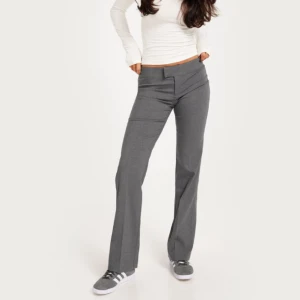 Grå Kostymbyxor  - Supersnygga grå kostymbyxor från Nelly. Aldrig använda, prislapp sitter kvar. Säljer pga de var för stora för mig 💗 Typ alltid slut på hemsidan