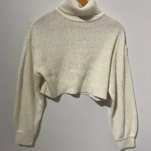 en krämvit croppad stickad tröja som har använts många gånger men i god skick. 