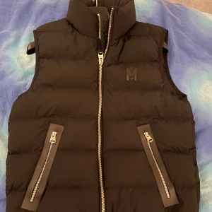 Mackage Väst - Svart/Mattsvart väst, super bra skick, 9,5/10. Kvitto, påse, tags och dustbag finns kvar, allt i ordinarie skick! Storlek 36/ S