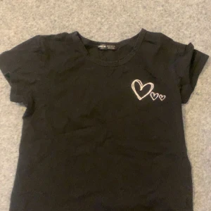 T-shirt - Svart t-shirt från shein med hjärtan på. Super fin och simpel tröja som passar till de mesta outfits. Kontakta mig på dm vid frågor och bilder om tröjan 