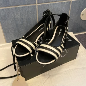 Svartvita finskor - Märke: Lola Ramona Storlek: 38 Orginalkartong medföljer. Fint skick: Knappt använda, bara en liten skada på sidan av klacken