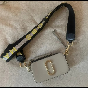 Marc Jacobs Snapshot - Säljer min superfina (såklart äkta) marc jacobs väska.  Köpt 2020 från nelly.com men kommer tyvärr inte till användning och är använt väldigt få gånger så är i fint skick.  Nypris cirka 4000 kronor. 