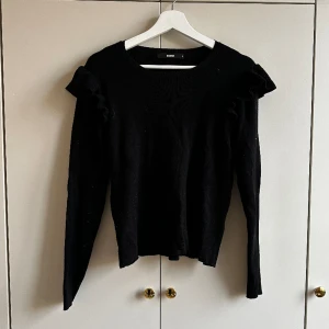Tröja med volanger - Svart tröja med volanger. I använt men bra skick. 