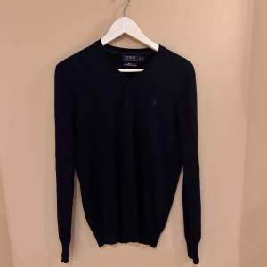Polo Ralph Lauren tröja mörkblå. Skicket på tröjan är nästan som ny. Användt ett par ggr. Tröjan är i merinoull!