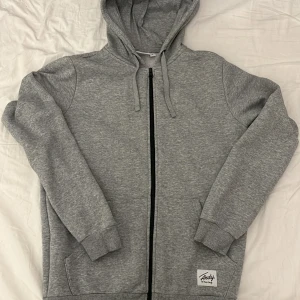 Frank Dandy ziphoodie - Grå zip-up hoodie från Frank Dandy i storlek S. Säljer för att den inte riktigt passar mig längre. Fint skick utan defekter.